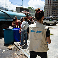 Fotografía de familias consiguiendo agua de camiones de agua de UNICEF