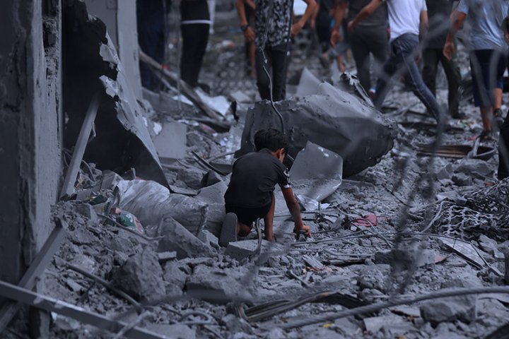 Fotografía de un niño entre los escombros de su casa, buscando sus juguetes.