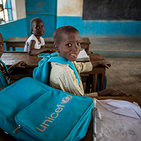 Fotografía de niños en su escuela con kits de educación recibidos por UNICEF