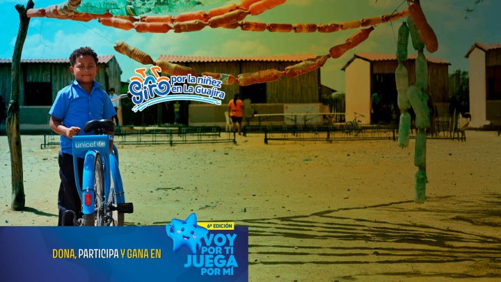 nino en cacerio de la guajira con su bicicleta bufalo mirando a la camara feliz y sonriente