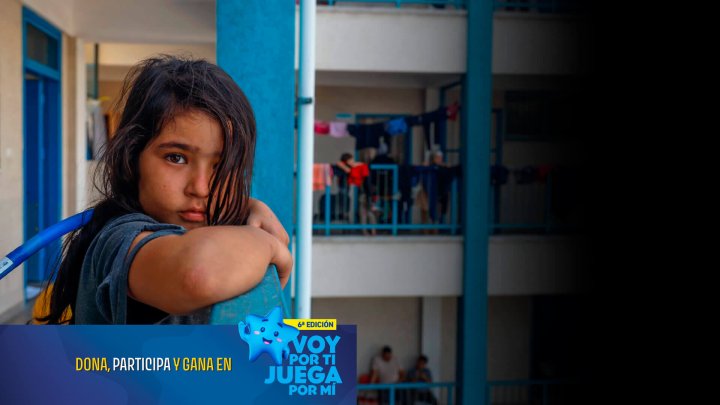 nina en una escuela mirando con tristeza a la camara mientras sobrevive a la guerra en una escuela que sirve como refugio temporal