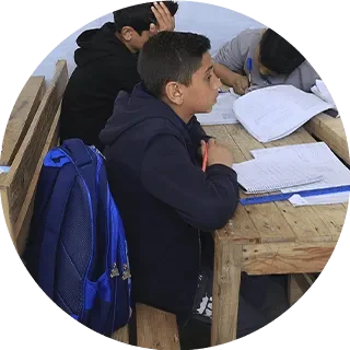 niño estudiando en escuela de UNICEF