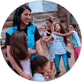 ninos jugando alrededor de funcionaria de UNICEF