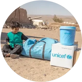 niño en medio del desierto con un kit de agua potable UNICEF